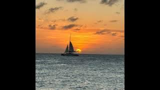 Photo of the sea at sunset with a sailboat